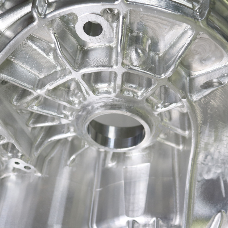Detail of an aluminum component showing a machined bore, ribs and toolpath texture