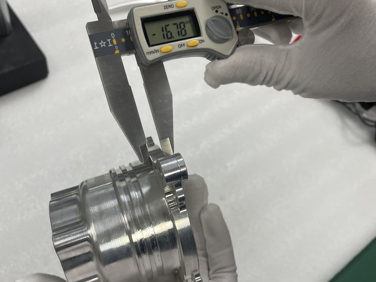 Digital caliper checking a machined metal component
